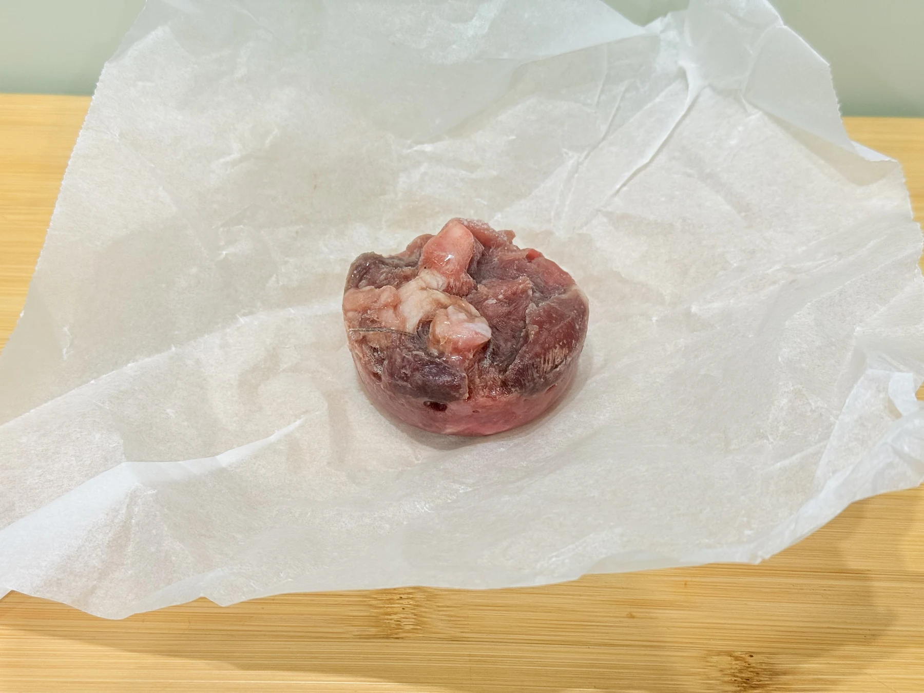 An unwrapped 70g Cats That Raw raw food puck